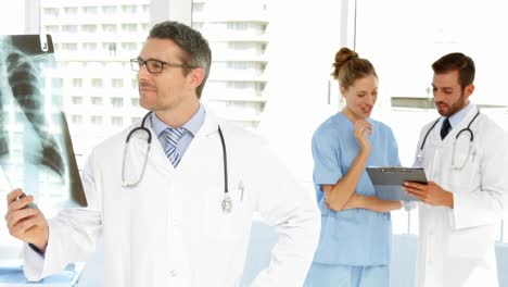 Doctor-looking-to-xray-then-smiling-at-camera