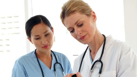 Two-doctors-looking-over-a-file-and-smiling-at-camera