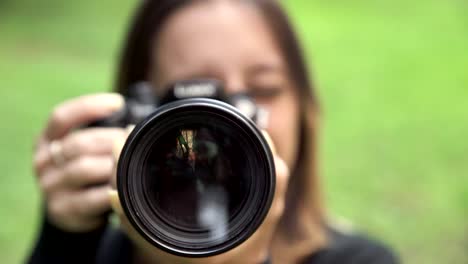 Junge-Fotografin-Frau-zeigt-das-Objektiv-an-der-Kamera