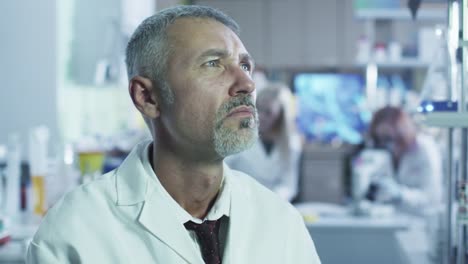 Portrait-of-a-senior-scientist-looking-at-a-display-in-a-laboratory.