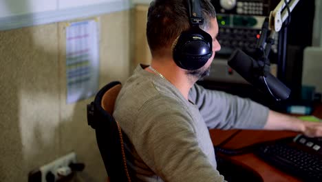 Radio-Moderator-am-Mikrofon-in-einem-live-Radio-broadcast-studio