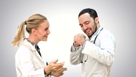 Happy-young-doctors-wearing-white-medical-overall-dancing-on-white-background