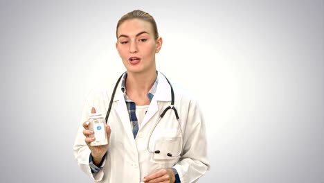 Pretty-female-doctor-describing-and-advertising-pills-for-the-camera-on-white-background