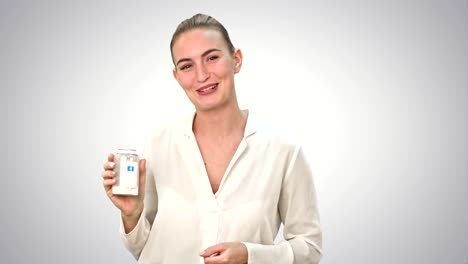 Hübsche-Frau-beschreiben-und-Werbung-Pillen-für-die-Kamera-auf-weißem-Hintergrund