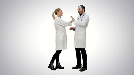 Funny-male-doctor-kidding-on-female-nurse-give-a-false-hi-five-on-white-background