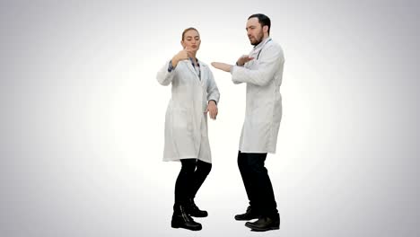 Two-funny-medical-doctors-with-funny-energy-dance-on-white-background