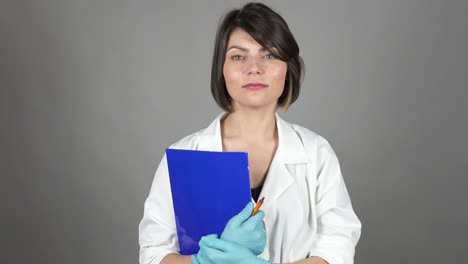 Friendly-young-nurse-holding-folder-isolated-on-grey-background.-Healthcare-concept.-Shot-in-4k.