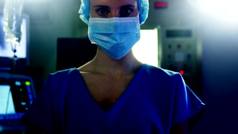 Portrait-of-female-surgeon-standing-with-arms-crossed-in-operating-room