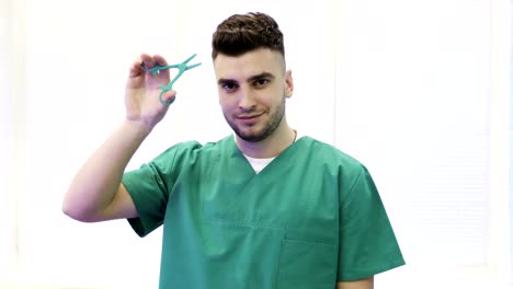 Cerca-de-un-joven-médico-en-médico-de-la-suit-muestra-clips-(tijeras).