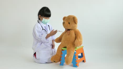 Asian-child-playing-doctor-with-bear-doll