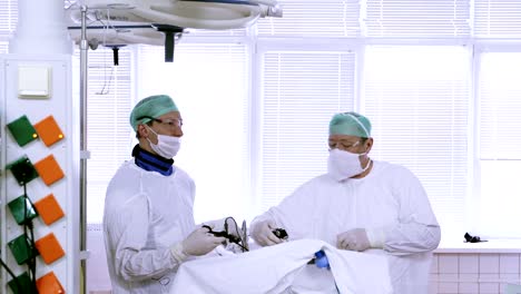 4K-dos-médicos-en-juegos-médicos,-máscaras-de-hacen-una-operación-laparoscópica-del-abdomen.