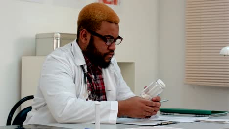 Americano-africano-macho-trabajador-médico-prescribir-píldoras