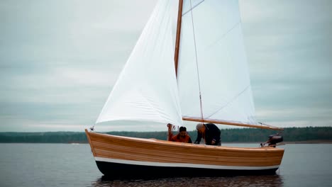 Velero-de-madera-con-dos-hombres-tratando-de-instalar-el-mástil