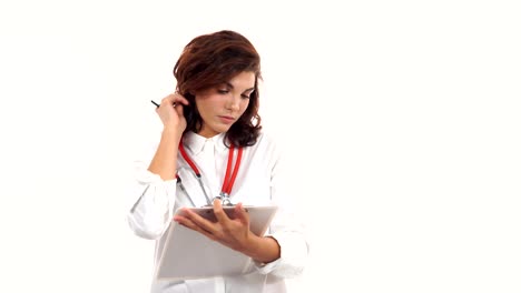 Friendly-young-female-doctor-reviews-and-writes-notes-on-a-clipboard.-Portrait-of-young-medical-professional-with-stethoscope-and-lab-coat-isolated-on-white-background