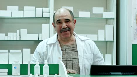 Portrait-of-senior-pharmacist-smiling-and-talking-to-a-camera