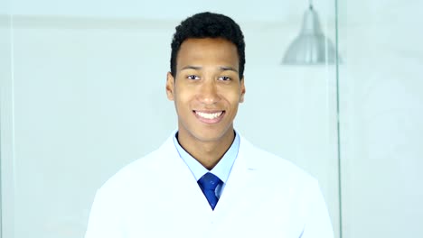 Sonriente-positiva-relajarse-afroestadounidense-médico-sentado-en-la-clínica,-cirujano