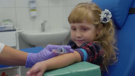 Nurse-is-taking-blood-sample-from-a-vein-in-the-arm-of-little-girl