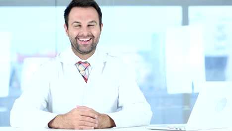 Portrait-of-Smiling-Positive-Doctor-Siting-in-Clinic