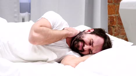 Beard-Man-with-Neck-Pain-Trying-to-Relax-in-Bed