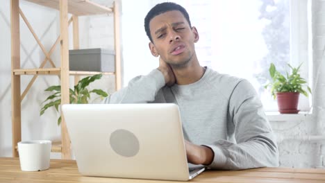 Nackenschmerzen,-müde-afro-amerikanischer-Mann-sitzen-bei-der-Arbeit