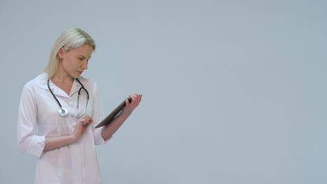 Happy-and-smiling-young-doctor-typing-text-on-the-tablet