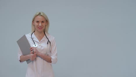 Portrait-of-a-female-doctor-with-white-coat-and-stethoscope-smiling-looking-into-camera