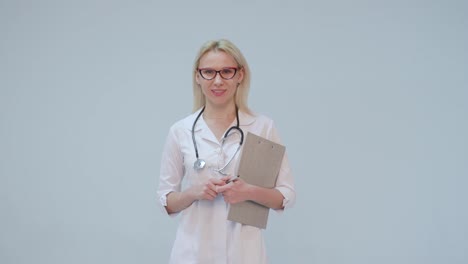 Portrait-of-a-female-doctor-with-white-coat-and-stethoscope-smiling-looking-into-camera