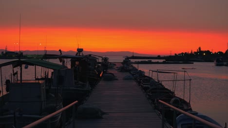 Abendstimmung-des-Kais.-Pier,-Boote-und-Orange-sky