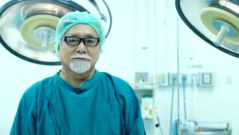 Senior-doctor-looking-to-camera-with-smiling-at-operation-room.-Healthcare-and-Medical-concept.