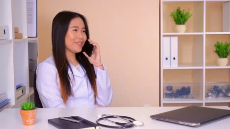 physician-speaking-by-mobile-in-office