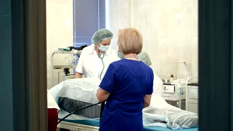 Doctors-managing-modern-endoscope-during-medical-procedure-at-hospital