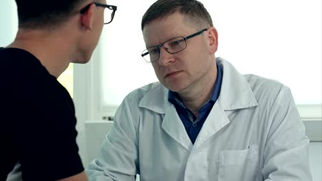 Male-doctor-in-glasses-consulting-male-patient