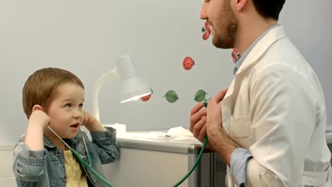 Young-boy-listening-to-doctor's-heart-with-stethoscope