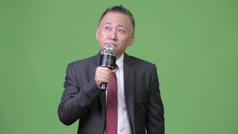 Mature-Japanese-businessman-using-microphone