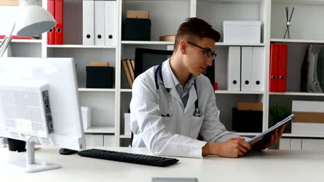 Joven-médico-mostrando-papel-y-sonriendo-a-cámara