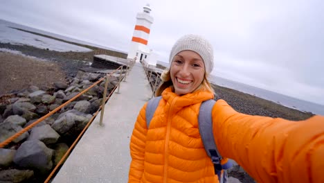 Travel-woman-taking-selfie-at-lighthouse-4K