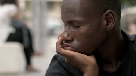 se-centran-en-el-hombre-africano-negro-joven-pensativo.-Pensamientos,-preocupaciones-al-aire-libre