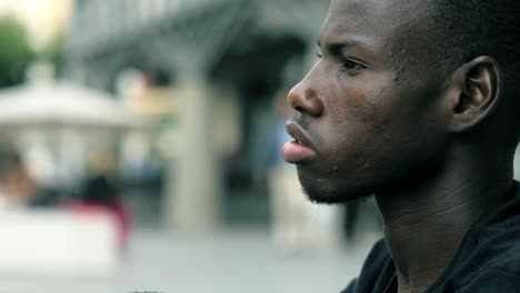 focus-on-Thoughtful-daydreaming-young-african-man-in-the-street--profile