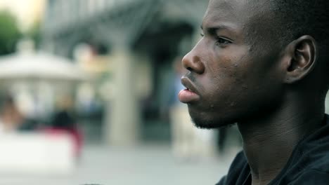 centrarse-en-pensativo-soñando-joven-africano-hombre-de-la-calle-perfil