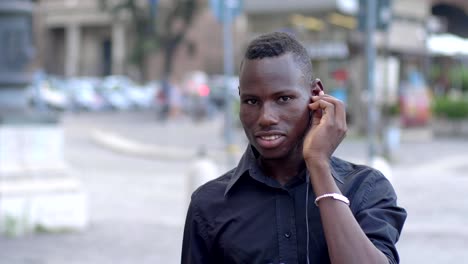 black-African-man-listens-to-music-following-the-rhythm-outdoor-slow-motion