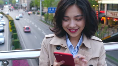 One-pretty-young-asian-woman-using-mobile-phone-in-the-city