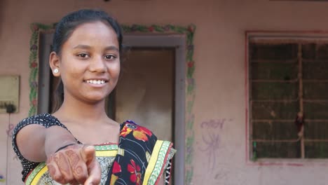 Mitte-Schuss-von-jungen-schönen-Indianerin-Punkte-Finger-viel-Glück-gute-Wahl-Zulassung-akzeptieren-ausgewählten-Kamera-mit-Henna-Tattoo-Hand-lächelnd-positive-zuversichtlich-Führer-Überzeugung-statische-Schuss