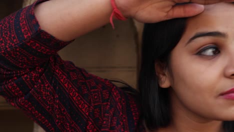 Handheld-shot-of-woman-waits-looks-search-far-around-at-her-smart-watch-phone-mobile-touch-screen-smiles-finds-at-camera--in-old-ancient-Hindu-temple-facade-backdrop-enter-frame-late-lover-pleased