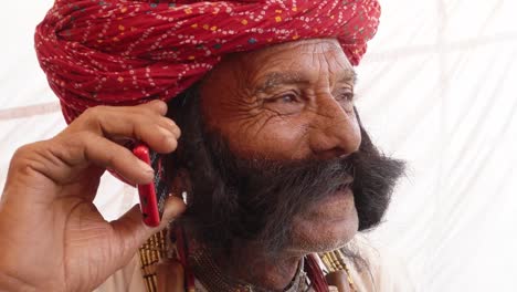 Hand-held-Rajasthani-elderly-male-on-a-smart-cell-phone-mobile-conversation