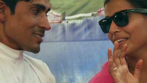 Beautiful-Indian-woman-wearing-sunglasses-and-pink-sari-with-her-man-in-red-turban-in-Pushkar,-Rajasthan,-India