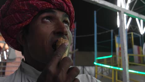 Hombre-indio-comiendo-helado-y-viendo-el-festival-de-carnaval-de-Pushkar-Mela-en-Rajasthan