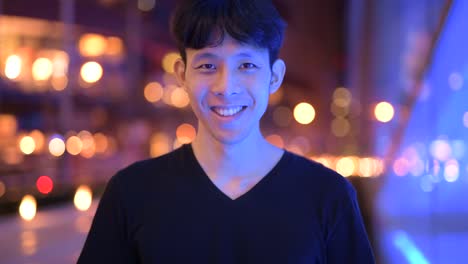 Portrait-Of-Asian-Man-Smiling-Outdoors-At-Night