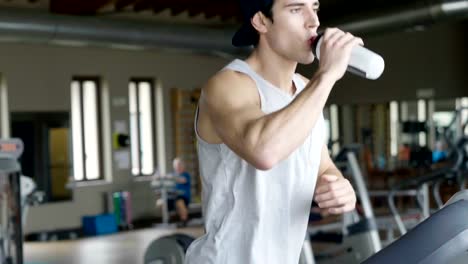 Un-chico-sin-camiseta-en-el-gimnasio,-entrena-su-cuerpo-para-mantenerse-en-forma-y-han-definido-los-músculos.-El-atleta-provoca-fatiga-y-cargas-pesadas.