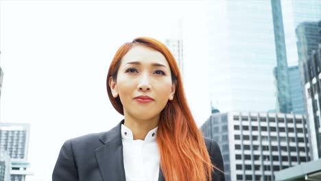 Close-up-tracking-shot-of-Young-attractive-Asian-business-woman-walking-in-the-urban-city-background