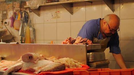 Un-hombre-hispano-pesa-pescado-en-un-mercado-de-pescado-en-México